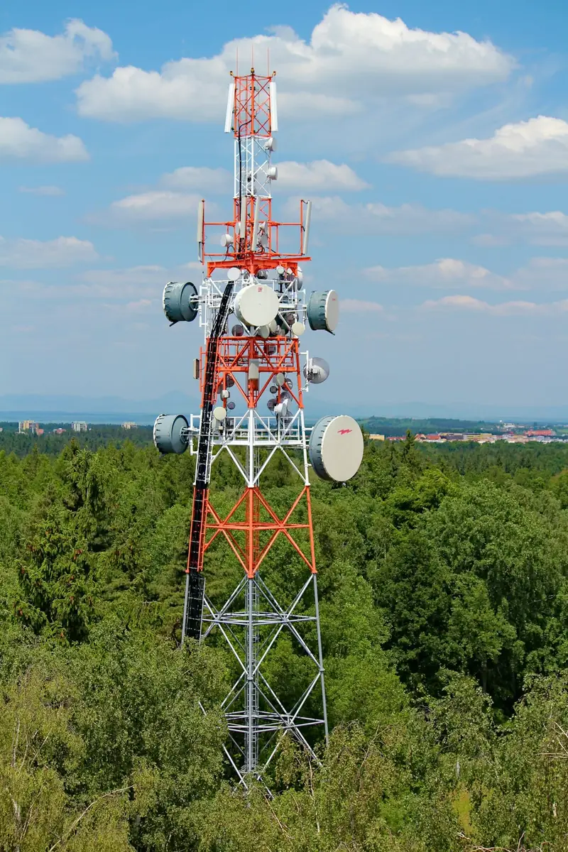 Torre de telecomunicaciones con antenas sobre un bosque